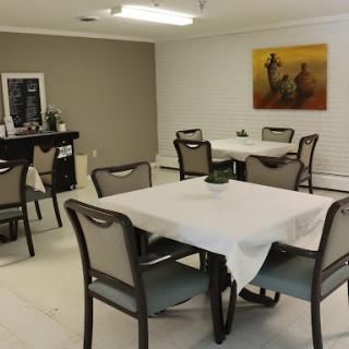 A cozy dining area featuring neatly set tables and a piece of wall art.