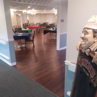A spacious dining area set up for an event, featuring tables and a decorative statue.