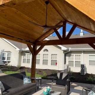 A cozy outdoor patio area under a wooden gazebo, perfect for relaxation and gatherings.