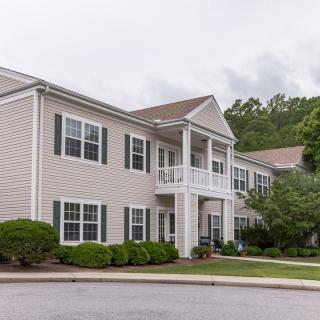 A suburban two-story apartment complex with neatly landscaped surroundings.