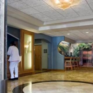 A modern lobby area with a person walking, featuring comfortable seating and stylish decor.