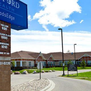 A view of a healthcare facility with clear blue skies and signage visible.