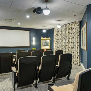 A cozy home theater with comfortable seating and a large projector screen.
