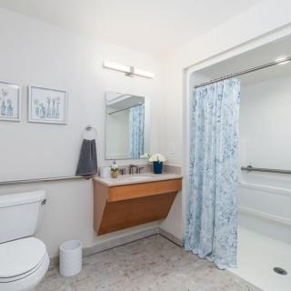 A clean and modern bathroom with a toilet, sink, and shower area.