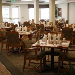 An empty dining room with neatly set tables and chairs.