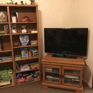 A cozy living room corner with a bookshelf and a television on a wooden cabinet.