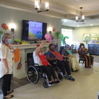 A lively gathering of senior citizens participating in a fun activity at a community center, with staff engaging and colorful decorations enhancing the festive atmosphere.