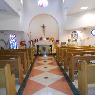 Interior view of a church showcasing the altar and seating for worshippers.