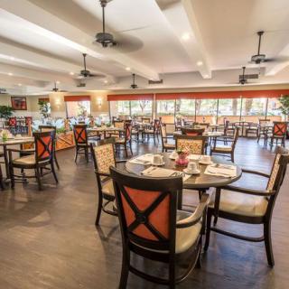 An elegantly set dining area in a spacious restaurant, showcasing neatly arranged tables and chairs.