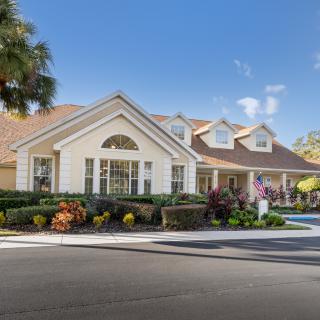 A suburban house with well-maintained landscaping and a clear blue sky.