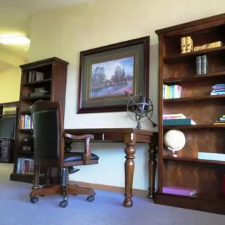 A well-organized office space with a desk, chair, and bookshelves.