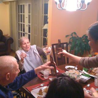 Family gathering around the dinner table, sharing a toast.