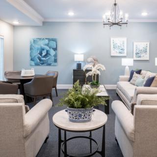 A beautifully decorated living room featuring comfortable seating, elegant artwork, and tasteful decor.
