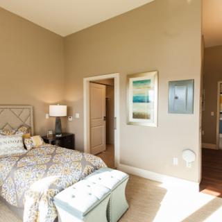 A cozy and stylish bedroom featuring a comfortable bed, decorative artwork, and soft lighting.
