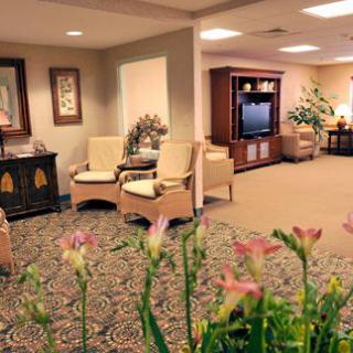 A cozy lobby with seating, a TV, and decorative plants.