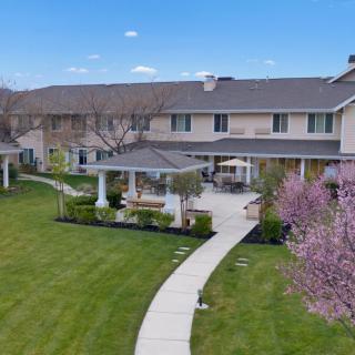 A spacious backyard with a well-maintained lawn and garden area behind a large residential house.