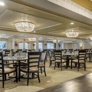An elegant dining area with arranged tables and chandeliers.