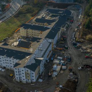 Aerial view of a construction site featuring multiple buildings in an urban environment.