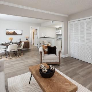 A modern open-concept living and dining area with neutral tones and minimalist decor.