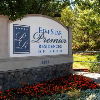 Entrance sign for Five Star Premier Residences of Reno surrounded by trees and flowers.