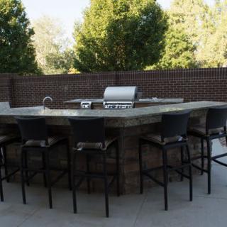 Outdoor patio with a barbecue grill and bar seating area.