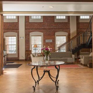 Cozy lobby with brick walls, featuring comfortable seating and a central table.