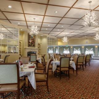 A spacious and elegantly designed dining room with chandeliers, offering a luxurious atmosphere for guests.