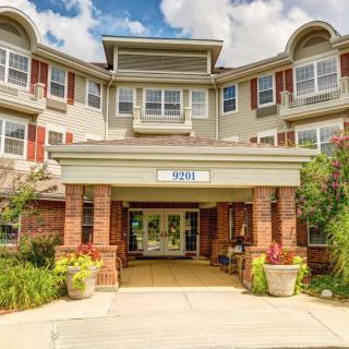A residential building with a welcoming entrance, featuring a covered porch and landscaping.