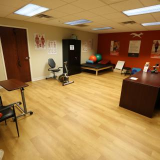 A physical therapy room equipped with exercise equipment and a treatment table.