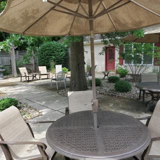 A cozy outdoor patio area with tables, chairs, and umbrellas set up for relaxation.