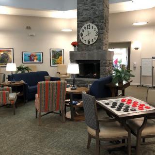 A cozy lounge area featuring a fireplace, game table, and comfortable seating.