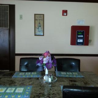 A restaurant table set with placemats and a flower arrangement in a cozy dining area.