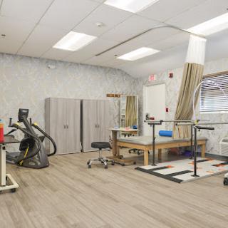 A modern rehabilitation therapy room equipped with various therapeutic equipment.