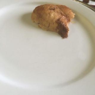 A small piece of meat on a large white plate.