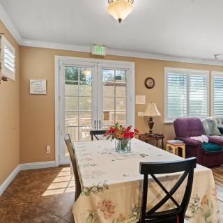 A cozy dining area with a table set for guests and a comfortable seating arrangement by the windows.