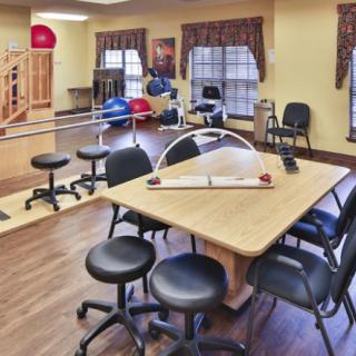 A well-equipped physical therapy and rehabilitation room featuring exercise equipment and seating.