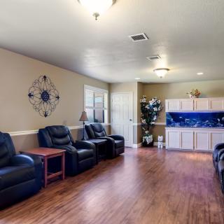 A spacious living room with leather chairs and hardwood flooring.