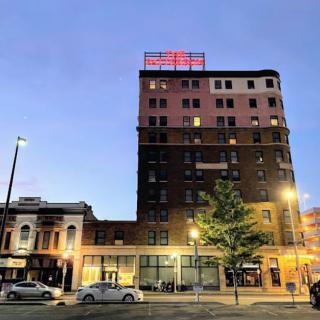 A city hotel building illuminated at dusk.