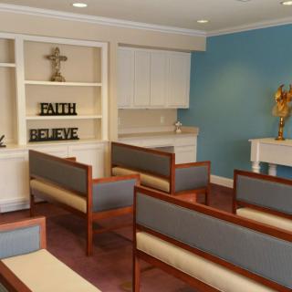 A small chapel with benches, a cross, and decorative elements for worship.