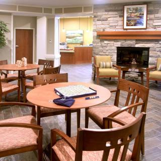 A cozy lounge area with tables, chairs, and a television.