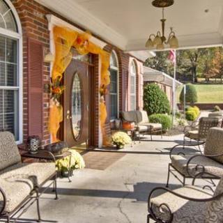A cozy porch adorned with fall decorations and comfortable seating.