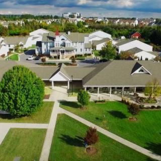 Aerial view of a suburban residential area with green spaces and cloudy skies.