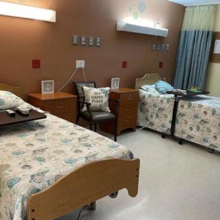 A clean and well-organized hospital room with two patient beds.