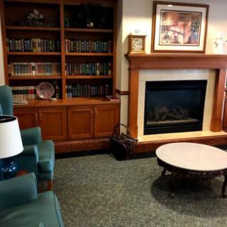 A cozy lounge area with a bookshelf, fireplace, and comfortable seating.