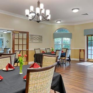 A well-decorated dining room with neatly set tables and elegant lighting.