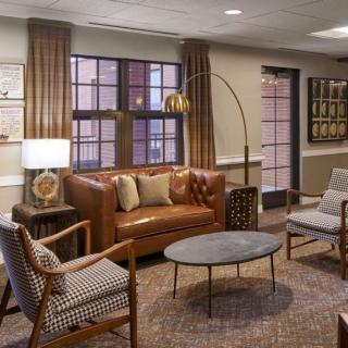 A cozy and stylish living room with a leather sofa, armchairs, coffee table, and decor.