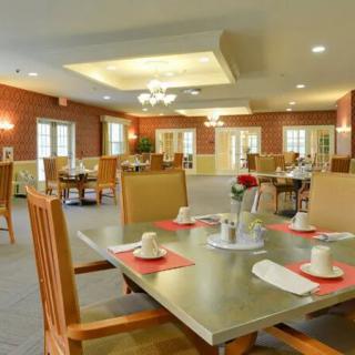 A spacious dining room with elegantly set tables and chairs.