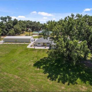 A spacious house with a large lawn and mature trees in the backyard.