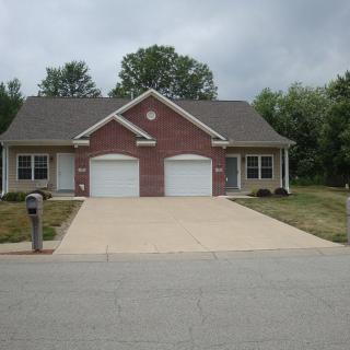 A suburban duplex with brick exterior and separate driveways.
