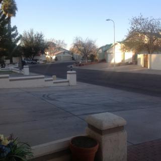 A quiet suburban street lined with residential houses on a clear day.